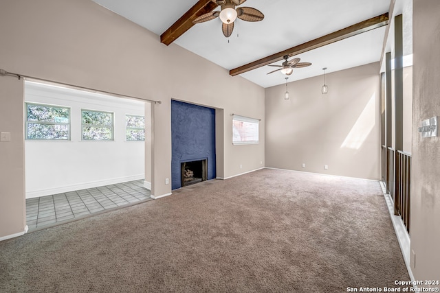 unfurnished living room featuring carpet, beam ceiling, plenty of natural light, and ceiling fan