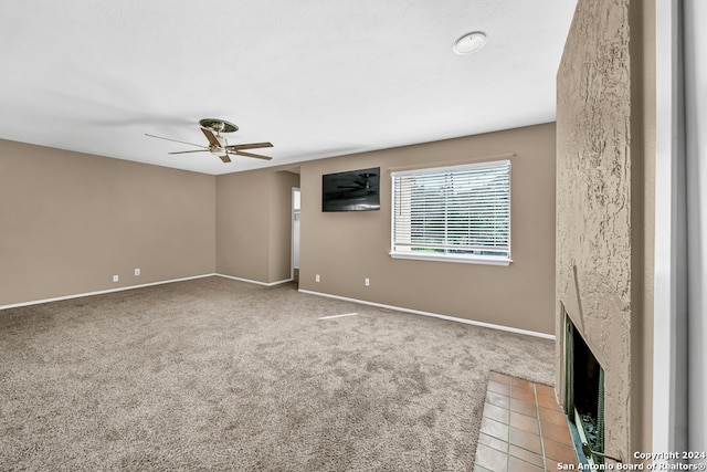 unfurnished living room with a fireplace, light carpet, and ceiling fan