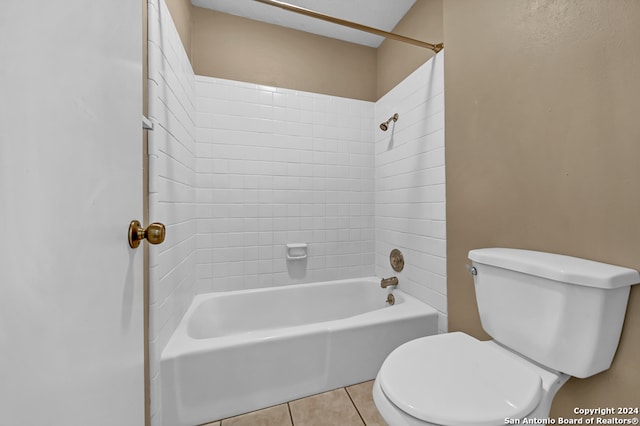 bathroom with tile patterned floors, toilet, and tiled shower / bath