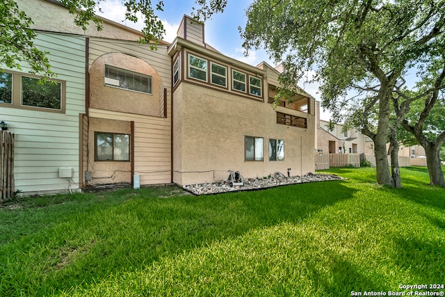 rear view of property featuring a lawn