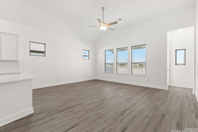 interior space featuring visible vents, baseboards, lofted ceiling, ceiling fan, and wood finished floors