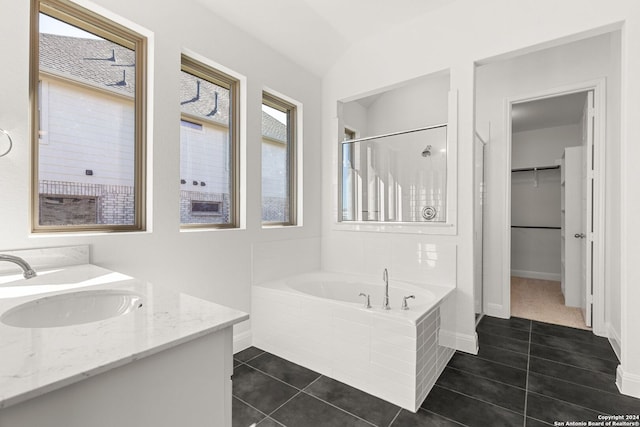 bathroom with tile patterned flooring, vanity, lofted ceiling, and plus walk in shower