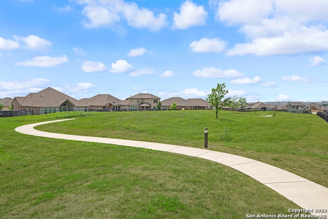 view of property's community with a residential view and a yard