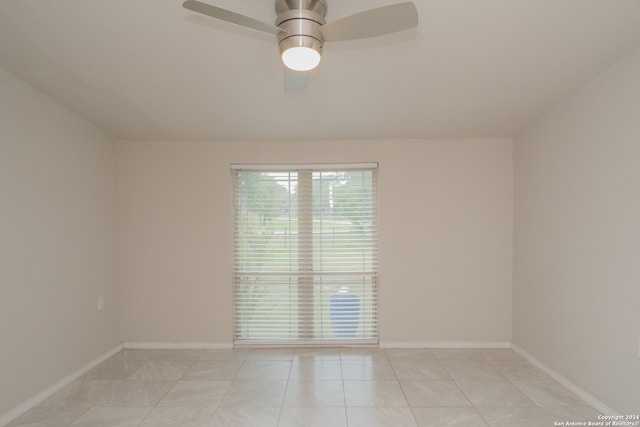 tiled spare room with ceiling fan