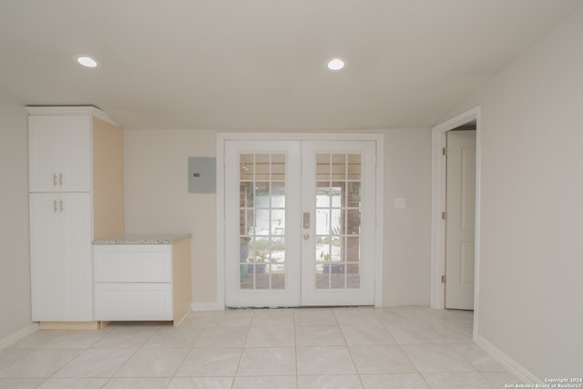 tiled empty room with electric panel and french doors