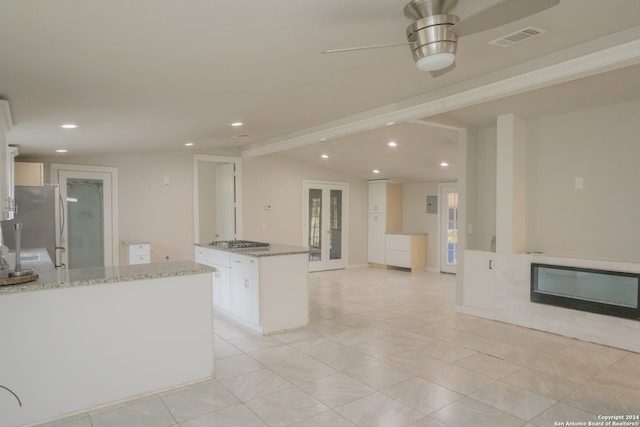 kitchen with french doors, light stone counters, stainless steel appliances, white cabinetry, and ceiling fan