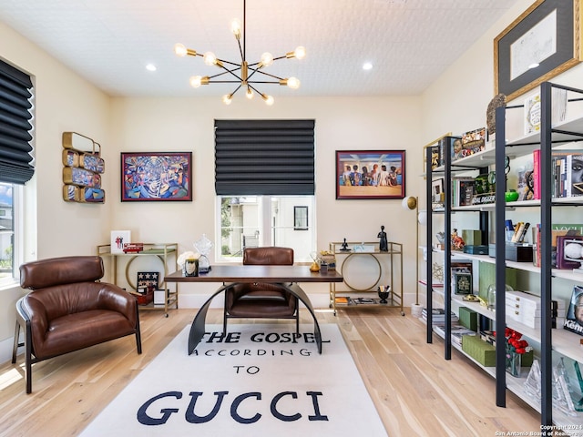 office with a wealth of natural light, light wood-type flooring, and a chandelier