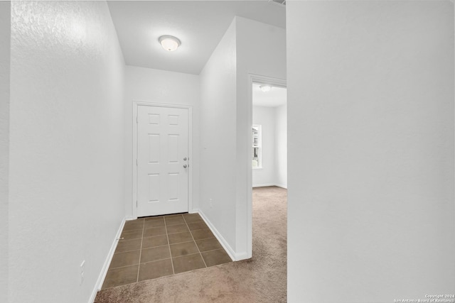 hall with dark carpet and baseboards