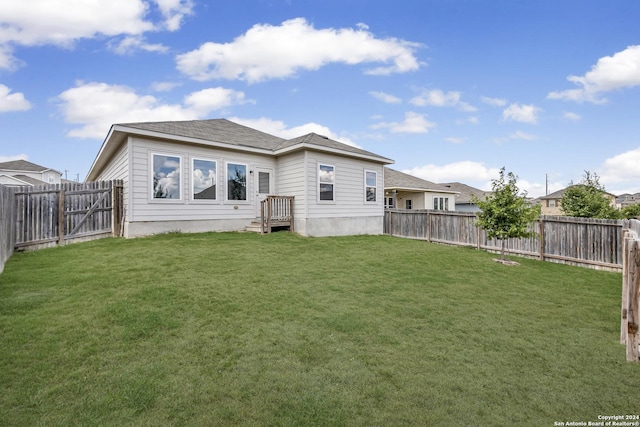 back of house featuring a fenced backyard and a lawn