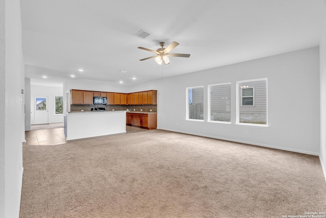 unfurnished living room with recessed lighting, light colored carpet, visible vents, ceiling fan, and baseboards