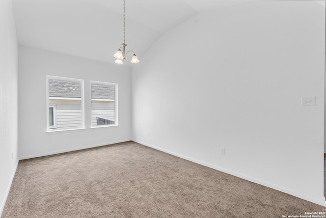 spare room with carpet, a notable chandelier, lofted ceiling, and baseboards