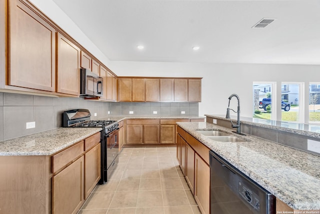 kitchen featuring light tile patterned floors, tasteful backsplash, visible vents, a sink, and black appliances