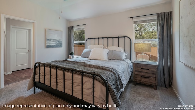 bedroom featuring dark carpet, multiple windows, and vaulted ceiling