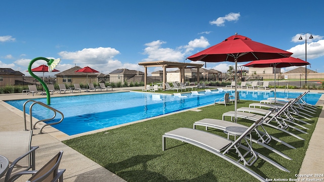 view of swimming pool with a yard