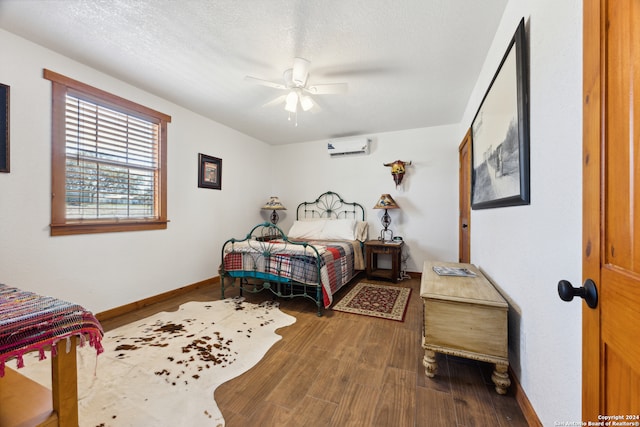 bedroom with a textured ceiling, a wall mounted AC, ceiling fan, and wood-type flooring