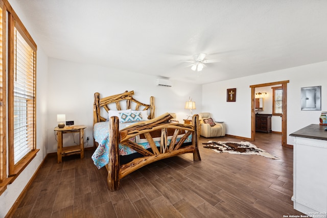 bedroom with ceiling fan, a wall unit AC, dark hardwood / wood-style flooring, and ensuite bath