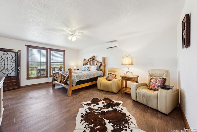 bedroom with dark wood-type flooring, a textured ceiling, a wall unit AC, and ceiling fan