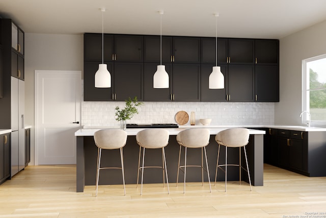 kitchen with sink, a kitchen island, decorative light fixtures, and decorative backsplash