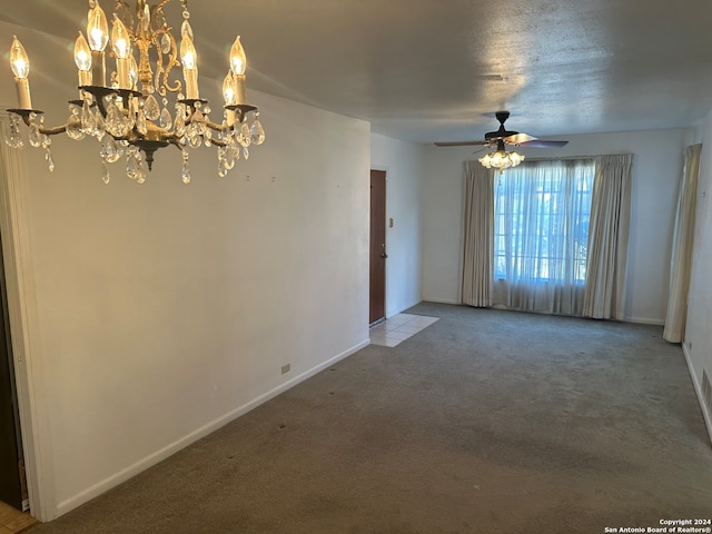 carpeted spare room with ceiling fan with notable chandelier