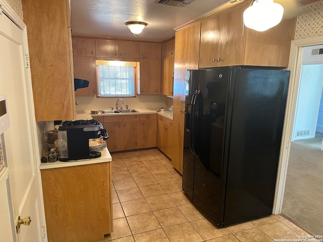 kitchen with black fridge, light carpet, and sink