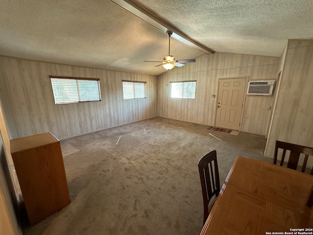 interior space with lofted ceiling with beams, plenty of natural light, ceiling fan, and carpet