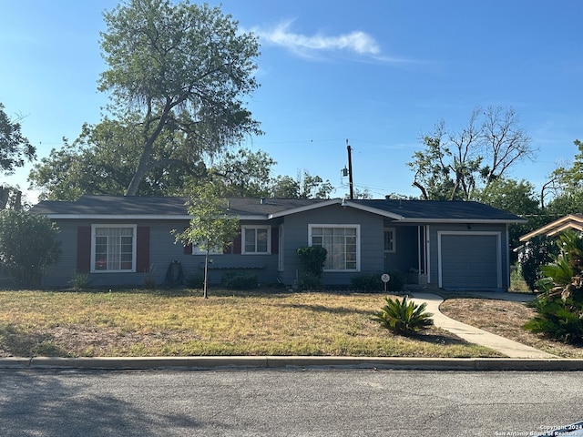 ranch-style house featuring a garage and a front lawn