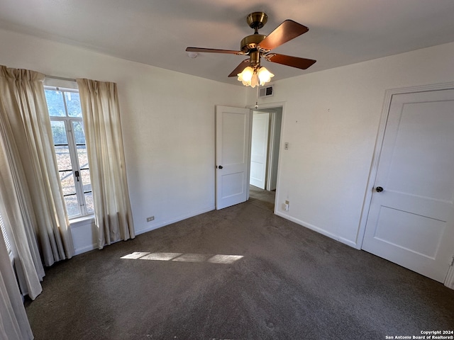 unfurnished bedroom with dark colored carpet and ceiling fan