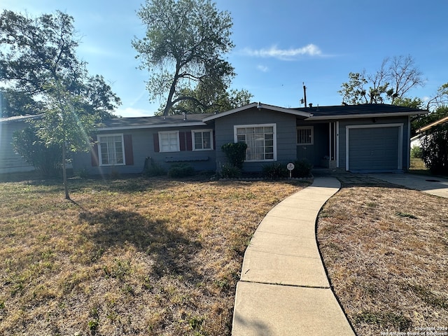 single story home featuring a garage and a front lawn