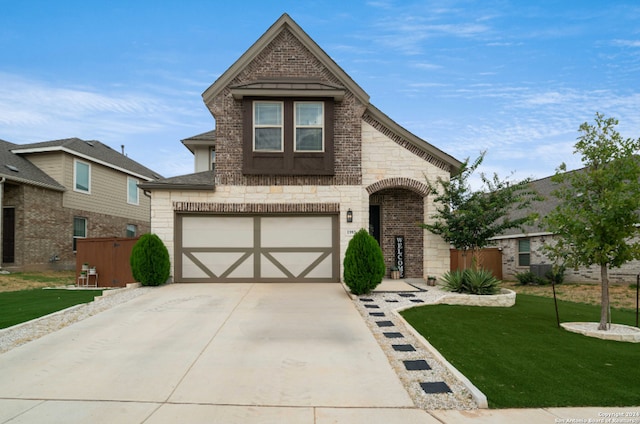 view of front facade featuring stone siding, concrete driveway, a front yard, a garage, and brick siding