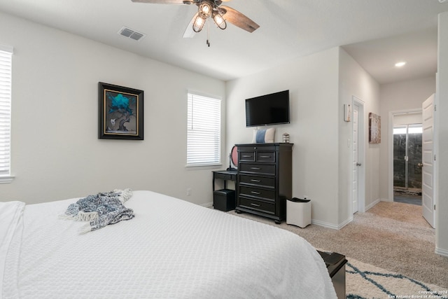 bedroom with visible vents, light carpet, baseboards, and ceiling fan