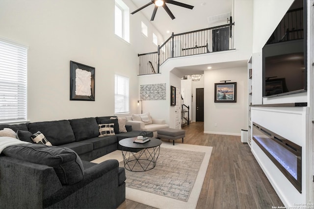 living room with dark wood finished floors, baseboards, and a ceiling fan