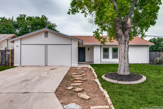 ranch-style house with a garage and a front lawn