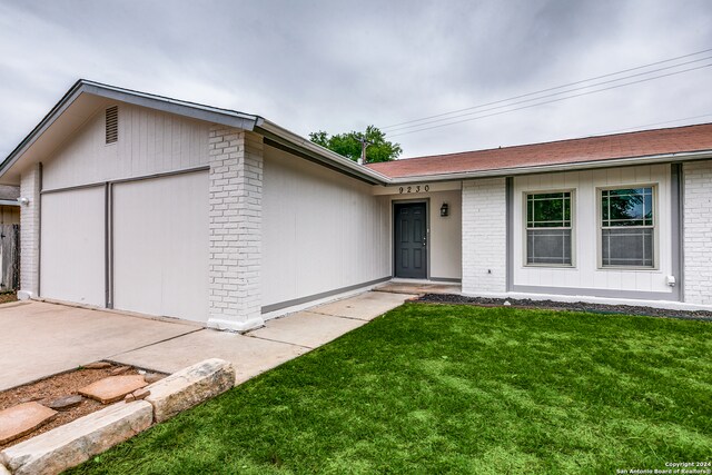 single story home featuring a garage and a front lawn