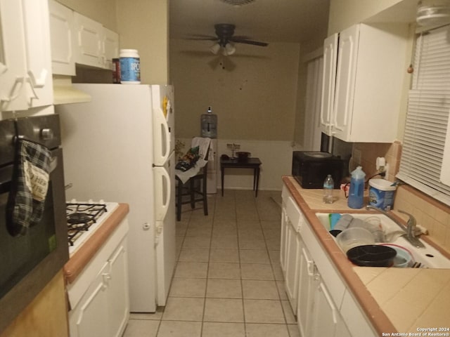 kitchen with white cabinetry, tile counters, light tile patterned floors, and ceiling fan