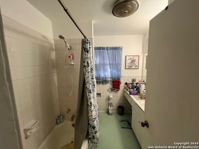 bathroom featuring tile walls, shower / tub combo, and vanity