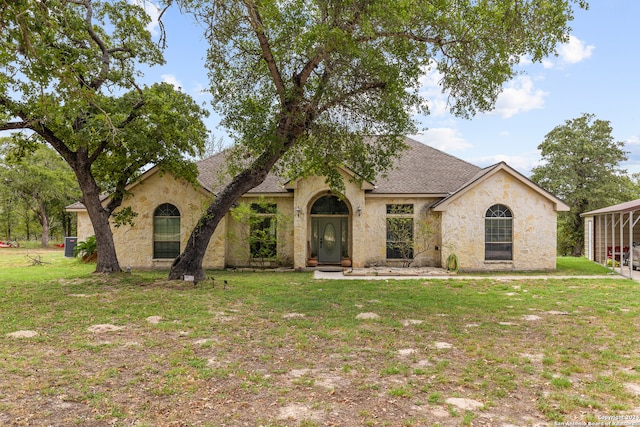 view of front of home with a front yard and a carport