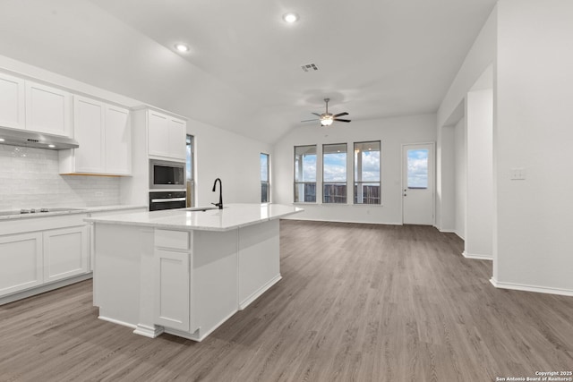 kitchen with appliances with stainless steel finishes, white cabinets, visible vents, and a sink