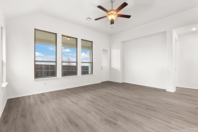 empty room featuring a ceiling fan, baseboards, visible vents, and wood finished floors