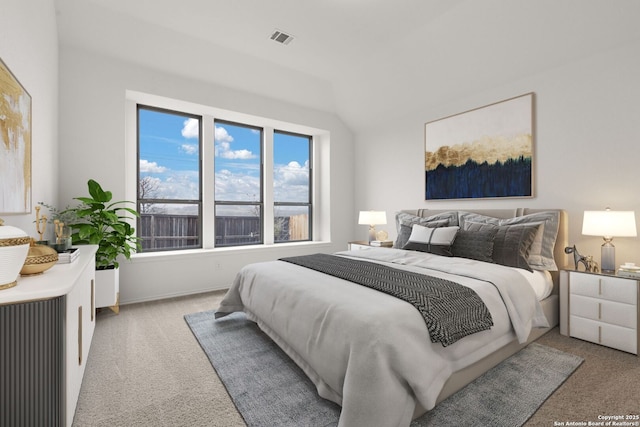 carpeted bedroom featuring lofted ceiling and visible vents