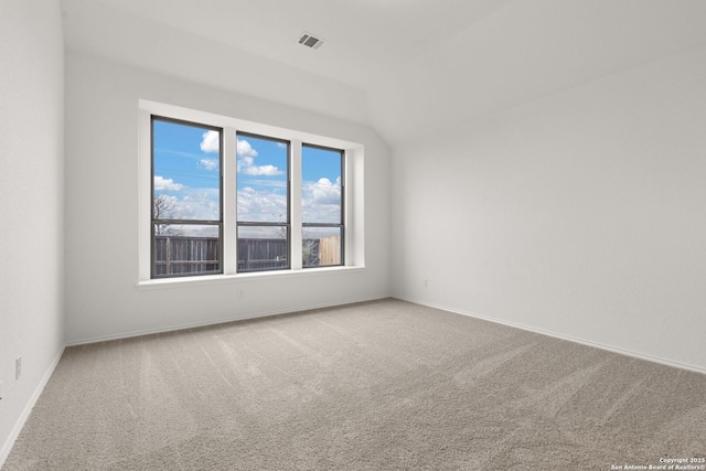 spare room with baseboards, visible vents, vaulted ceiling, and carpet flooring