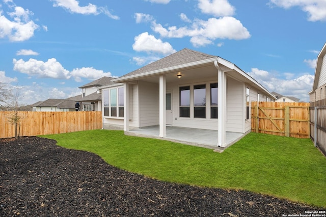 back of house with a yard, roof with shingles, a patio area, and a fenced backyard