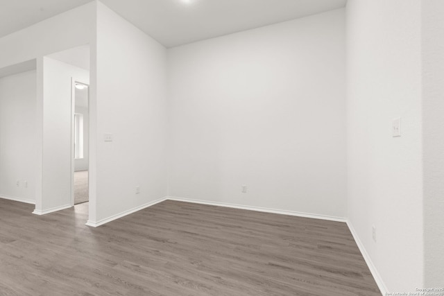 unfurnished room featuring wood finished floors and baseboards