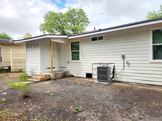 back of house with central AC unit