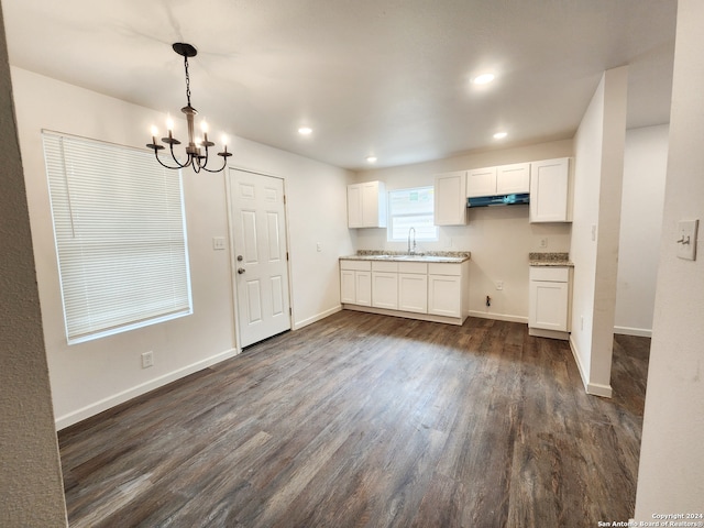 kitchen with white cabinets, pendant lighting, an inviting chandelier, and dark hardwood / wood-style flooring