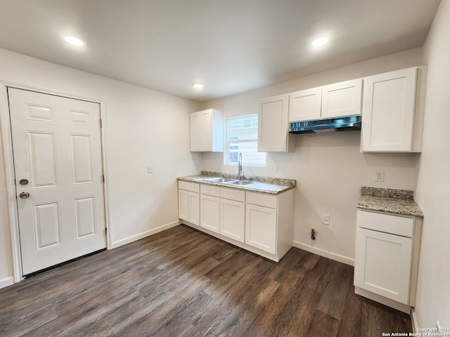 kitchen featuring dark wood-type flooring, light stone counters, sink, and white cabinets