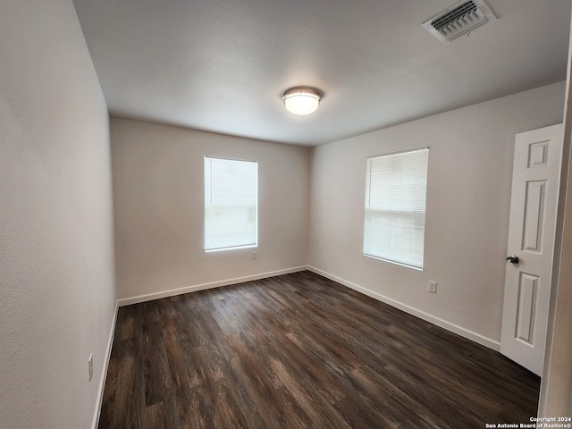 spare room with dark hardwood / wood-style flooring