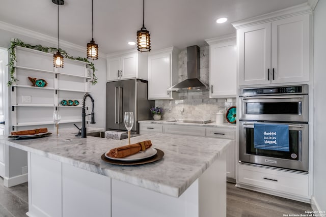 kitchen featuring light stone counters, stainless steel appliances, light hardwood / wood-style floors, wall chimney exhaust hood, and tasteful backsplash