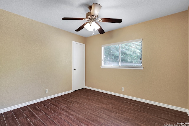 empty room with a textured ceiling, dark hardwood / wood-style flooring, and ceiling fan