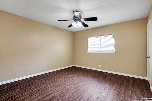 empty room featuring ceiling fan, a textured ceiling, and dark wood-type flooring