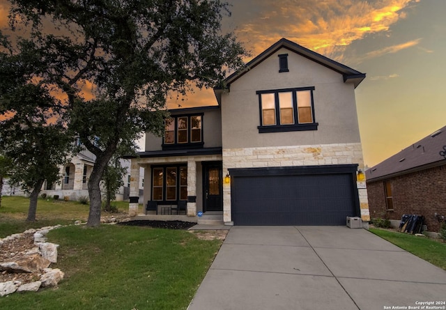 view of front of house featuring a front lawn, concrete driveway, stucco siding, a garage, and stone siding